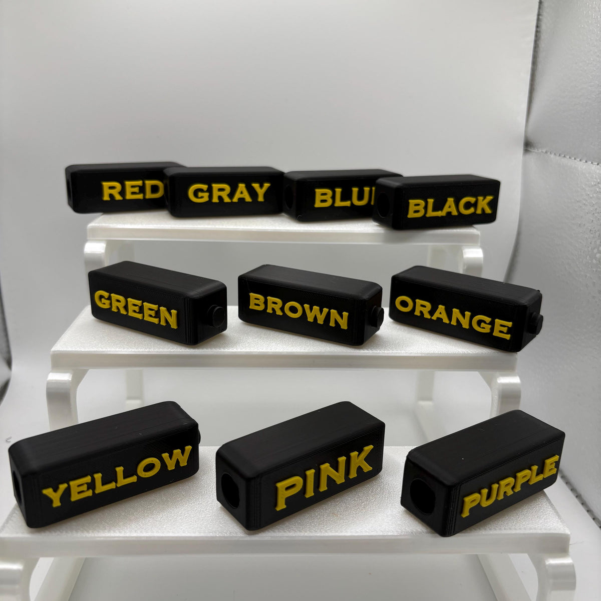 Set of 10 high contrast braille marker toppers, yellow on black